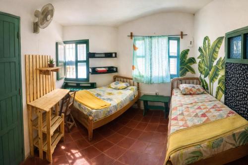 a room with two beds and a table at Viento Este Guest House in Popoyo