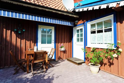 a patio with a table and chairs next to a house at Lana in Nida