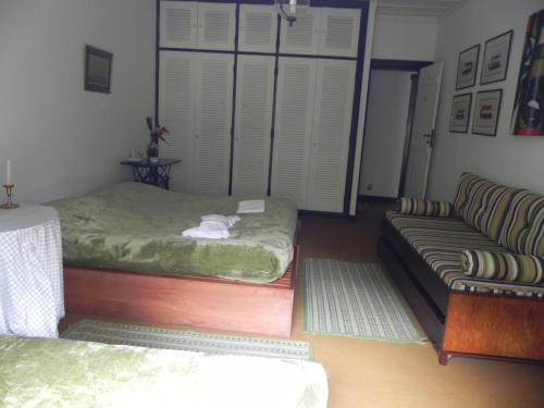 a living room with a bed and a couch at Casa do Fachoalto in Petrópolis
