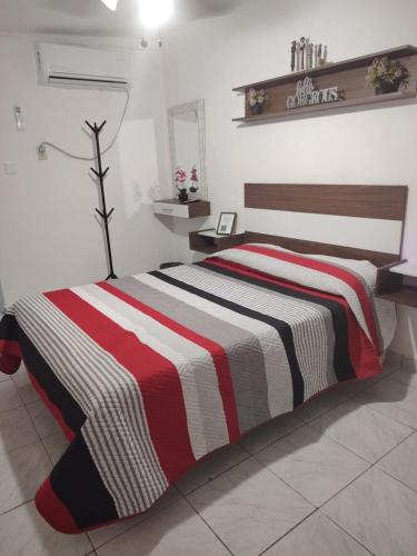a bedroom with a bed with a striped blanket at Casa centrica in Hermosillo