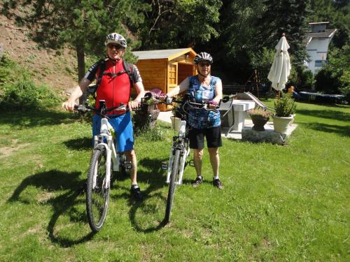 two people standing with their bikes in the grass at Ferienhaus Burgblick in Treffen