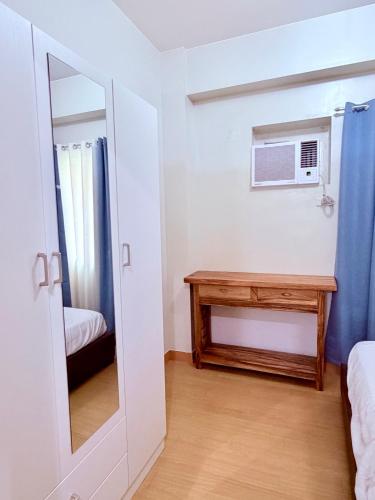 a room with a mirror and a table and a microwave at TIRPT Staycation in Manila