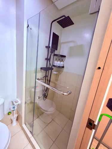 a bathroom with a glass shower with a toilet at TIRPT Staycation in Manila