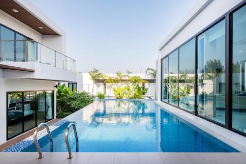 an image of a swimming pool in a house at Movenpick Residences 3-Bedroom Pool Villa Beach Access, Na Jomtien Pattaya in Na Jomtien