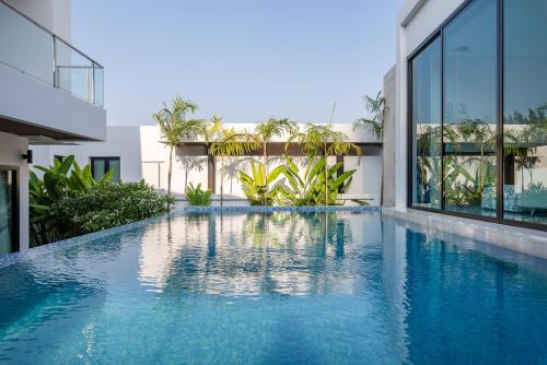a swimming pool in the middle of a building at Movenpick Residences 3-Bedroom Pool Villa Beach Access, Na Jomtien Pattaya in Na Jomtien