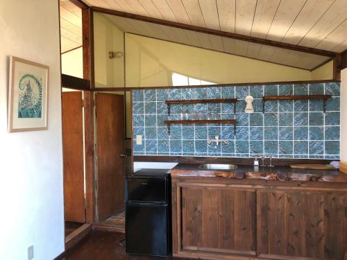 a kitchen with a sink and a blue tiled wall at Emeraldia in Tateyama