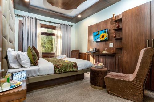 a bedroom with a bed and a chair and a window at Hotel grandlords in Pahalgām
