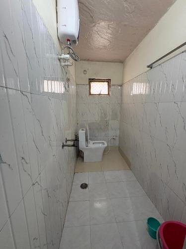 a bathroom with a toilet and a window at Shri Nimbark Mohini Kunj in Vrindāvan