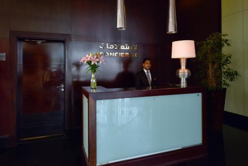 a man in a suit in a lobby with a large screen at Sofitel Al Khobar The Corniche in Al Khobar