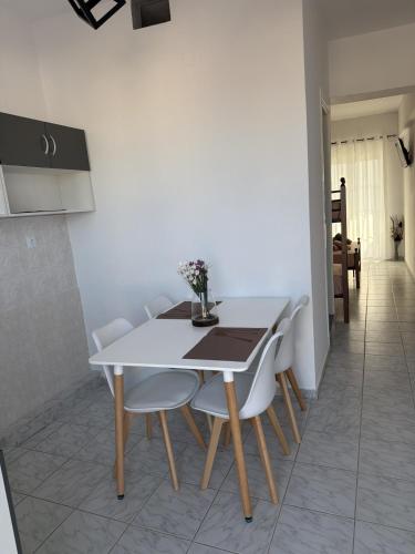 a dining room table with white chairs and a white table at Matinas rooms in Nea Mesangala