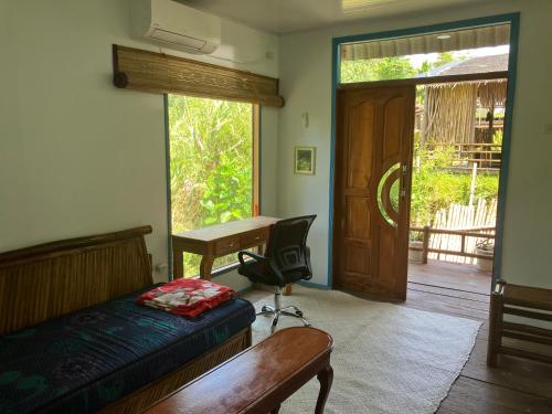 a bedroom with a bed and a desk and a door at Cucu Suzanne in Lasikin