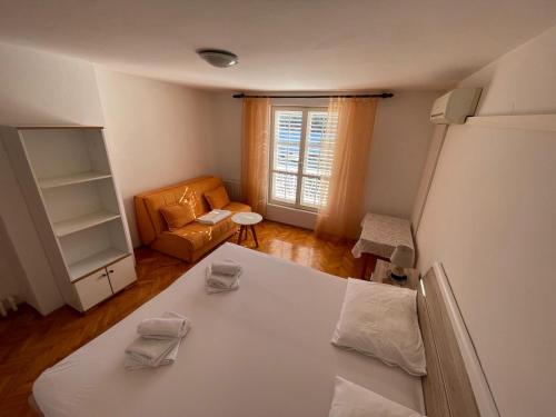 a living room with a bed and a couch at Apartment Bugenvila in Vrboska