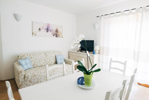 a living room with a white table and a couch at Le Ville Le Saline in Palau