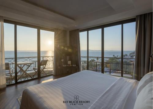 a bedroom with a bed and a view of the ocean at Bay Beach Resort Jomtien in Jomtien Beach