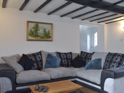 a living room with a couch and a table at Boundary Cottage in Unstone