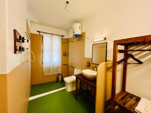 a bathroom with a sink and a toilet and green floor at Hotel Sairaj inn - Restaurant - Free Wi-Fi - Premium Rooms - Balcony - Parking in Puri