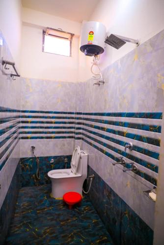 a bathroom with a toilet with a red seat at Shri ram doot niwas in Ayodhya