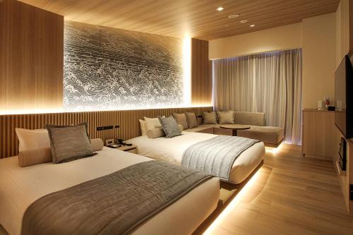 a hotel room with two beds and a couch at La'gent Stay Hakodate Ekimae in Hakodate