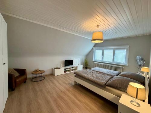 a bedroom with a large bed and a television at Ferienhaus Malente in Malente