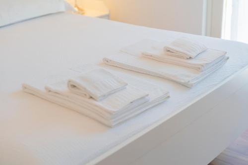 two piles of towels sitting on a white table at giardino e piscina apartment in Bellagio