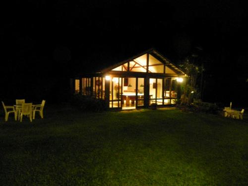 a house lit up at night with a table in the yard at Casa do Fachoalto in Petrópolis