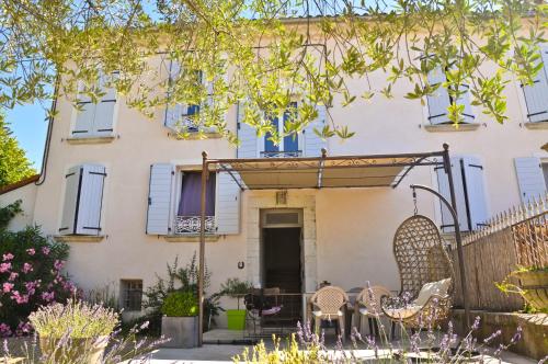 Casa blanca con ventanas azules y valla en Maison d'hôtes Le Jas Vieux en Montfort