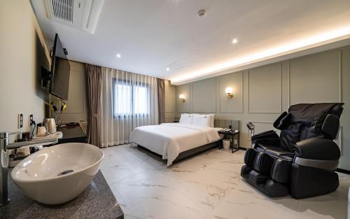 a hotel room with a bed and a bath tub at 호텔이데아 울산삼산점 in Ulsan