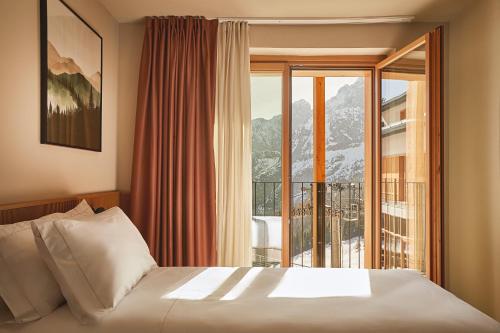 a bedroom with a bed and a large window at Rifugio Colere 1600 by Cloud 7 in Colere