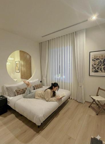 a woman laying on a bed in a room at The Atelier House in Krabi