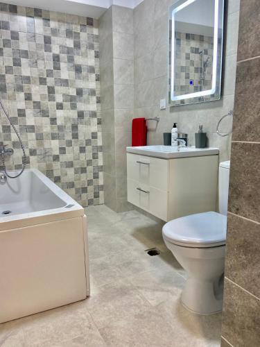 a bathroom with a toilet and a sink and a mirror at Iulius Mall New Residence in Iaşi