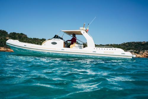 a man is sitting in a boat in the water at Le Ville Le Saline in Palau