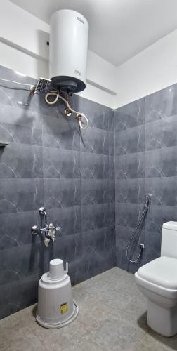 a bathroom with a white toilet and a sink at Elevate 1478 Inn in Nandigunda