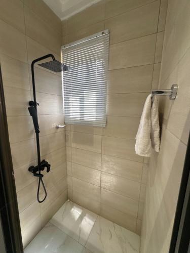 a bathroom with a shower with a window at Luxueux duplex 2-bedroom in Ashalebotwe