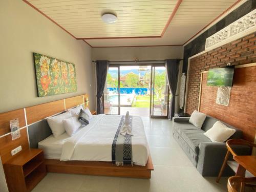 a bedroom with a bed and a couch at Nada Garden villa in Jinengdalem