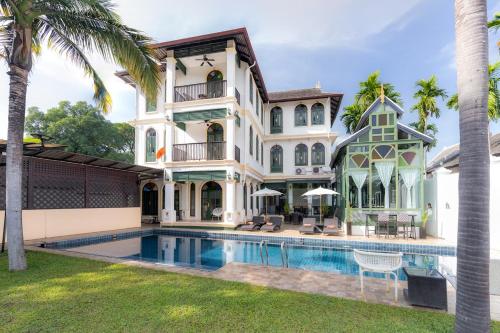 an exterior view of a mansion with a swimming pool at Cheva Gallery Boutique Hotel in Chiang Mai