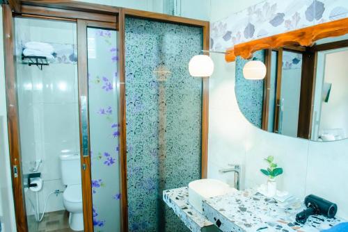 a bathroom with a shower and a sink and a toilet at Nada Garden villa in Jinengdalem