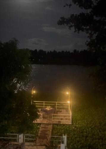 a dock on a lake at night with lights at Sedna hotel in Mahawewa