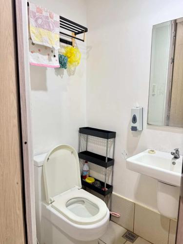 a small bathroom with a toilet and a sink at Blanc Suite in Pasong Bayog