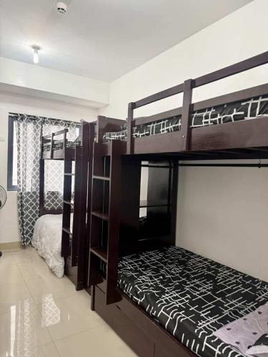 two bunk beds in a room with a bed at Blanc Suite in Pasong Bayog