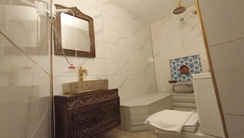 ein Badezimmer mit Waschbecken, Toilette und Spiegel in der Unterkunft Rumetpaşakonağı in Mardin