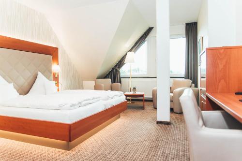 a hotel room with a large bed and a desk at Ringhotel Teutoburger Wald in Tecklenburg