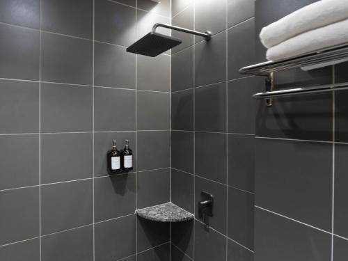 a bathroom with a shower with two bottles of wine at Green Hotel in Puchong