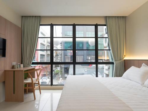 a bedroom with a bed and a large window at Green Hotel in Puchong