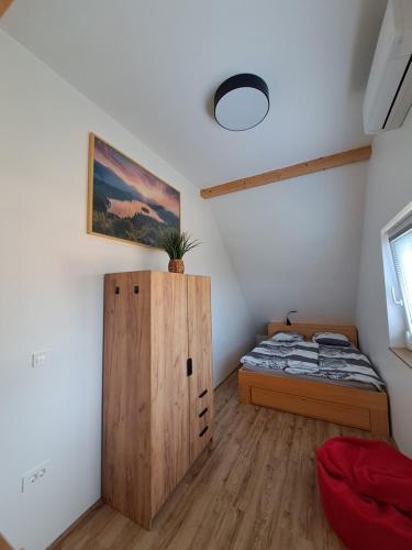 a bedroom with a bed and a wooden cabinet at Bella Apartment in Žirovnica