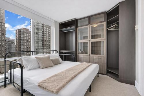 a bedroom with a bed and a window at Modern Corner apartment in downtown in Vancouver
