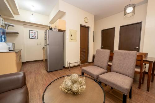 a living room with a table and chairs and a refrigerator at 2BR Cloud 512 with Parking Slot in Baguio