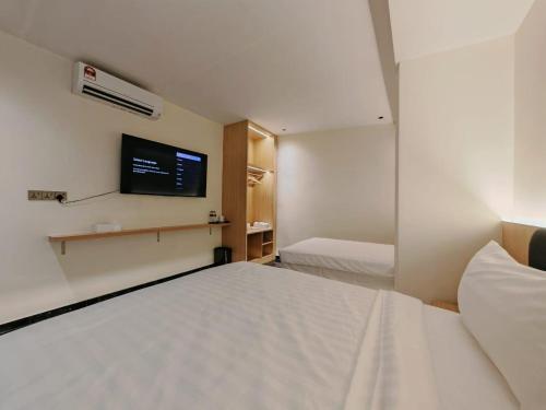 a hotel room with a bed and a flat screen tv at Hotel Classic in Malacca