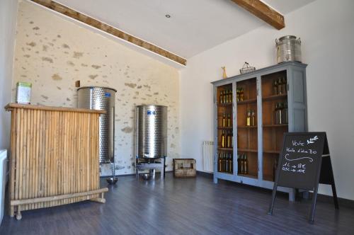 a room with two wine tanks and a shelf of wine bottles at Maison d'hôtes Le Jas Vieux in Montfort