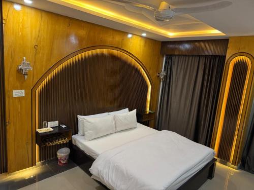a bedroom with a bed and a wooden wall at Peaceful Stay In Peshawar in Peshawar
