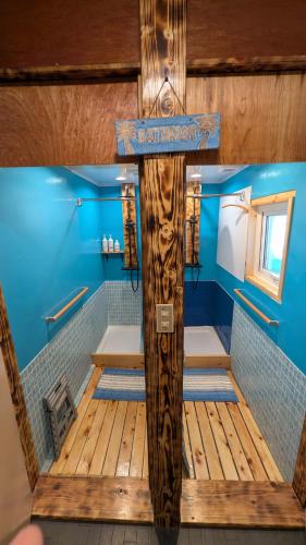 a wooden cross in a bathroom with blue walls at Tokachi Base Camp in Kami-furano